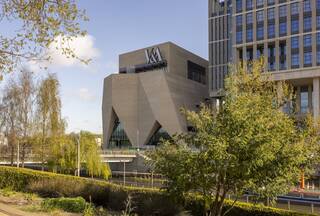 V&A East from across the waterways framed by trees